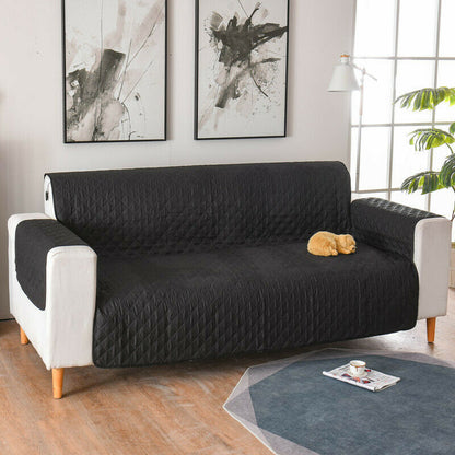 a black and white couch with a cat sleeping on it